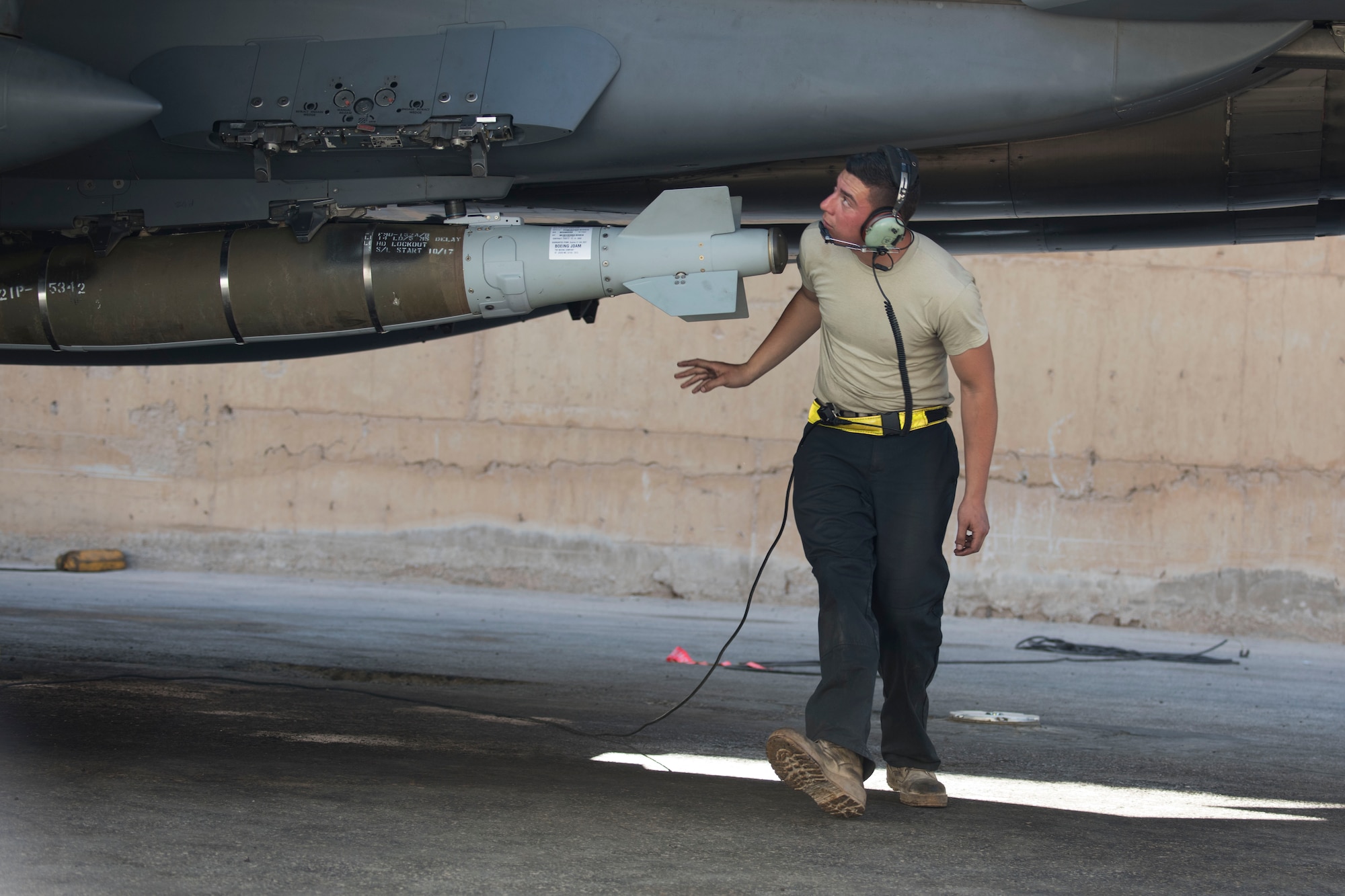 A 332nd Expeditionary Maintenance Squadron crew chief, examines an F-15E Strike Eagle as part of pre-checks for takeoff March 7, 2018, at an undisclosed location in Southeast Asia