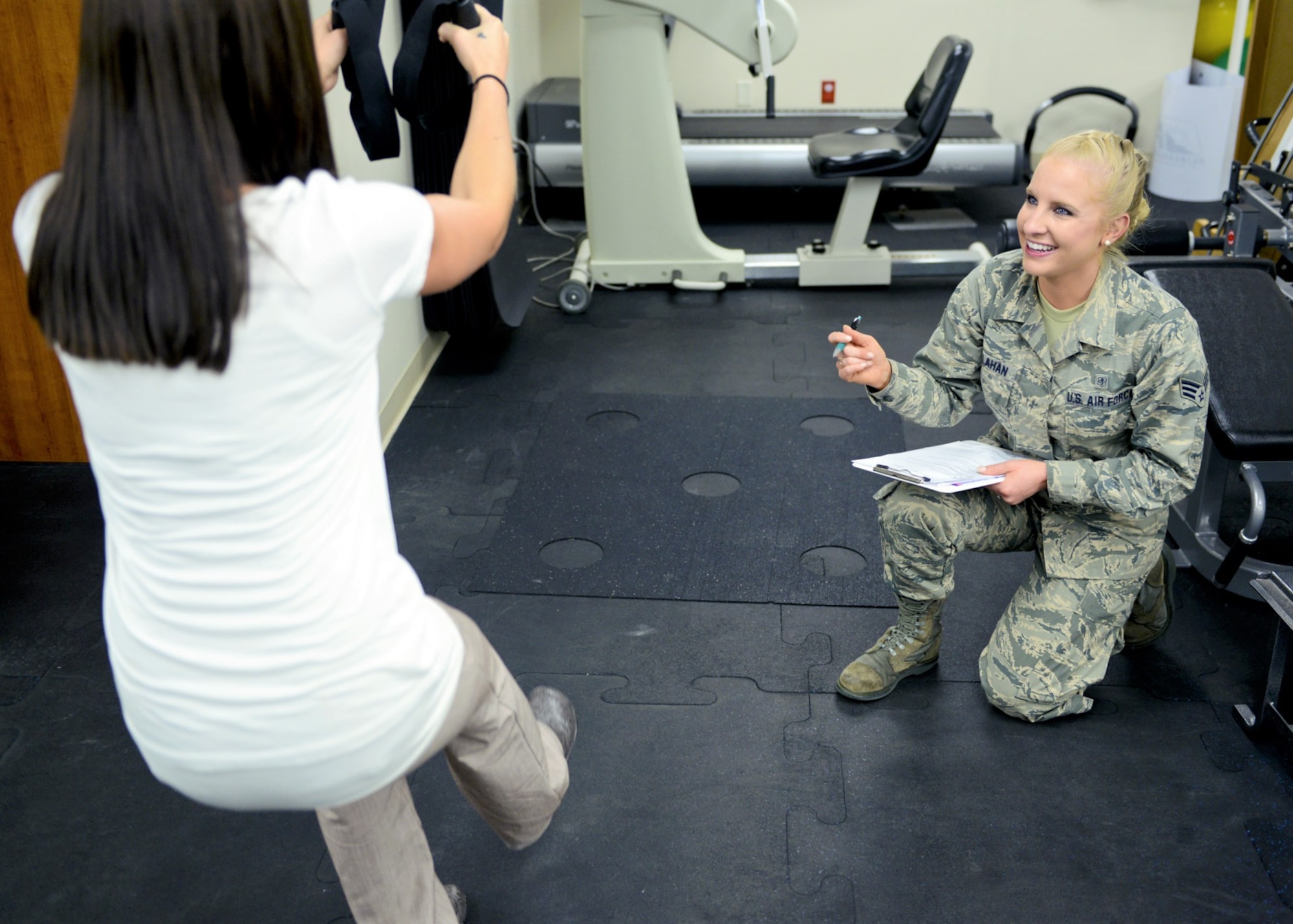 Then Senior Airman Kaitlyn Callahan, 341st Medical Operations Squadron physical medicine technician, instructs a patient through a modified squat at Malmstrom Air Force Base, Montana, July 2017. Callahan helped develop several programs to help Airmen build strength and prevent injury. (U.S. Air Force photo)
