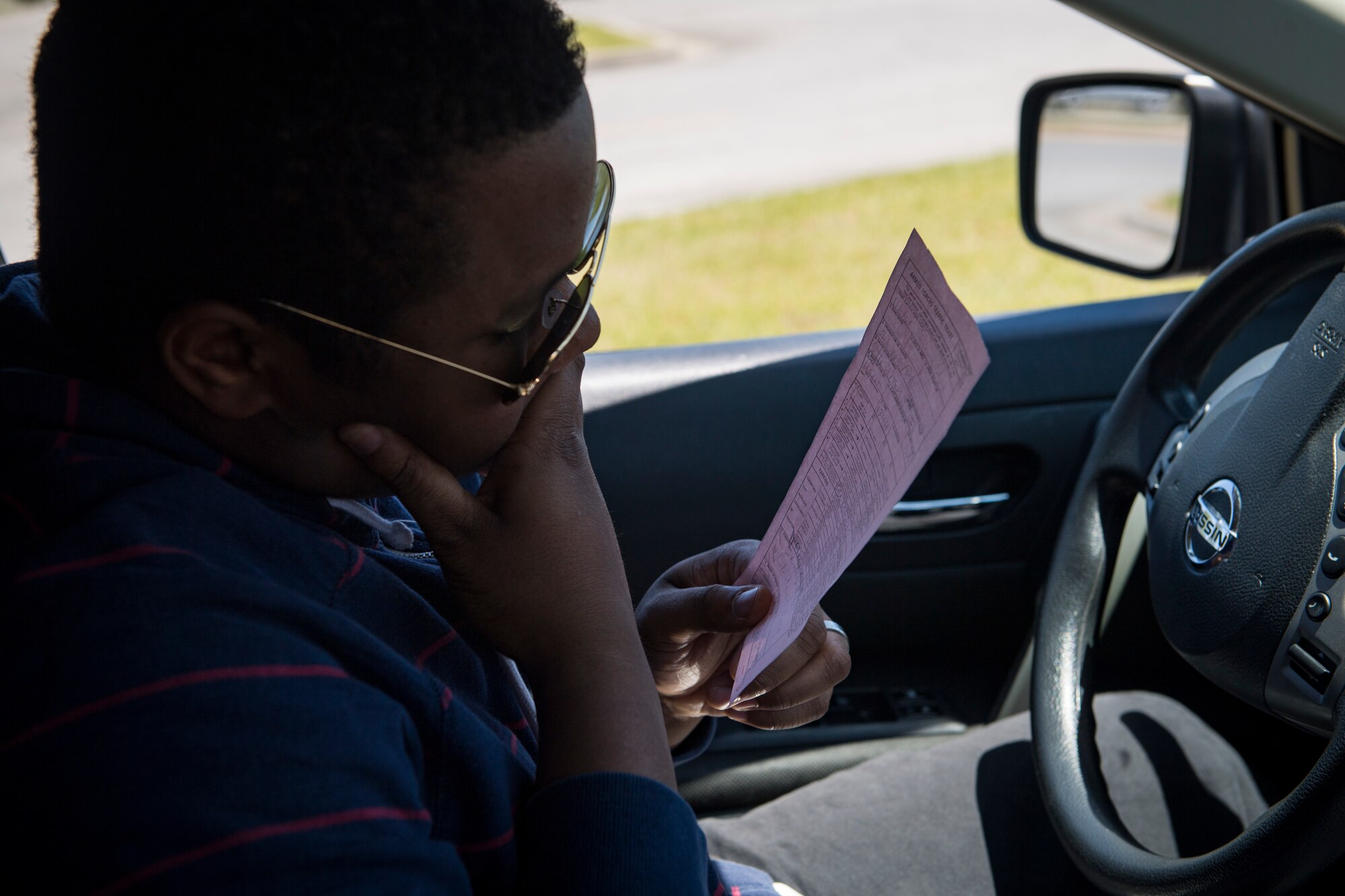 Airman 1st Class Eugene Oliver, 23d Wing photojournalist apprentice, reads a citation during a simulated distracted driving traffic stop, April 17, 2018, at Moody Air Force Base, Ga. Since January 2018 there have been 13 distracted driving incidents at Moody, which has prompted the SFS patrolmen to heavily enforce distracted driver consequences for motorists on the installation. (U.S. Air Force photo by Senior Airman Janiqua P. Robinson)