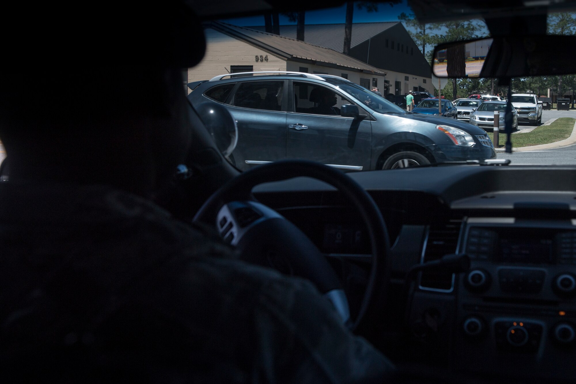 Tech. Sgt. Jamaal Smalls, 23d Security Forces Squadron (SFS) flight chief, watches Airman 1st Class Eugene Oliver, 23d Wing photojournalist apprentice, drive-by while on his cell phone during a simulated distracted driving traffic stop, April 17, 2018, at Moody Air Force Base, Ga. Since January 2018 there have been 13 distracted driving incidents at Moody, which has prompted the SFS patrolmen to heavily enforce distracted driver consequences for motorists on the installation. (U.S. Air Force photo by Senior Airman Janiqua P. Robinson)