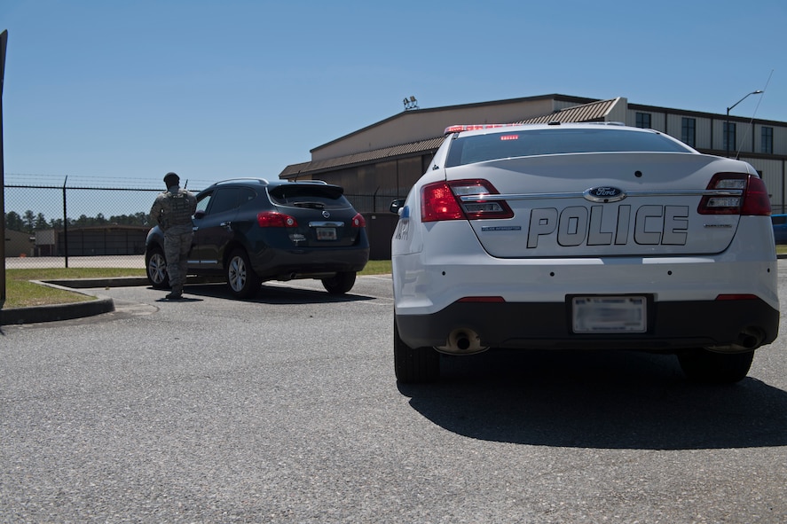 Tech. Sgt. Jamaal Smalls, 23d Security Forces Squadron (SFS) flight chief, approaches a vehicle during a simulated distracted driving traffic stop, April 17, 2018, at Moody Air Force Base, Ga. Since January 2018 there have been 13 distracted driving incidents at Moody, which has prompted the SFS patrolmen to heavily enforce distracted driver consequences for motorists on the installation. (U.S. Air Force photo by Senior Airman Janiqua P. Robinson)