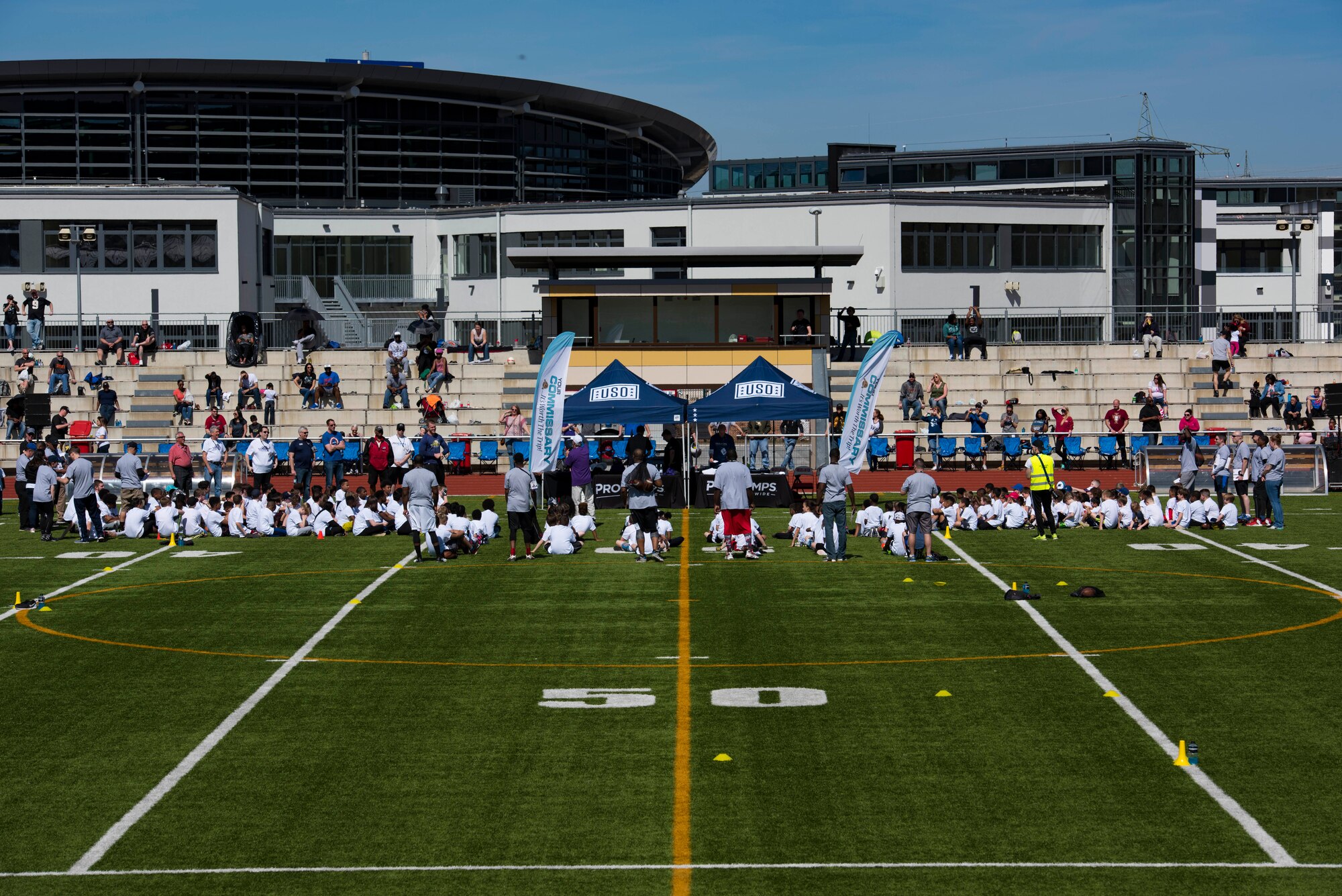 Children of Kaiserslautern Military Community members, grades 1st through 8th, gather for the free NFL football camp hosted by Kyle Rudolph, Minnesota Vikings tight end, at the Kaiserslautern High School football stadium on Kapaun Air Station, Germany, April 7, 2018. Autographs and pictures with Rudolph were given to each camp attendee.