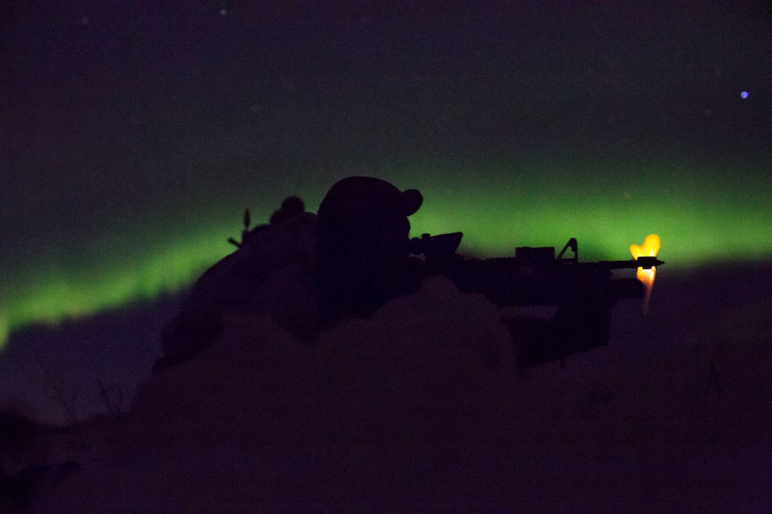 Marine with Marine Rotational Force-Europe conducts a mountainous assault on enemy position as the northern lights shine above during the field training exercise portion of Exercise White Claymore near Bardufoss, Norway, February 15, 2018. White Claymore is a U.K. Royal Marines-led training in northern Norway that focuses on winter warfare including training on movement in adverse terrain and over snow, and training in defensive and offensive operations in winter conditions.