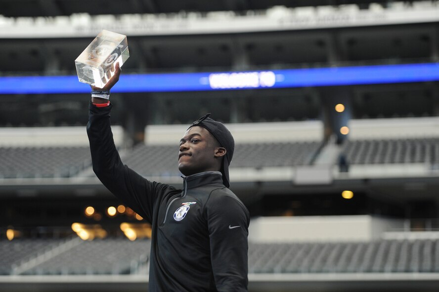 Airman Donovan V. Lewis, an Air Force technical school trainee at Goodfellow, stands with his first place trophy at the 2nd Annual Caliber Collison Military Combine finals at the Dallas Cowboys AT&T Stadium in Arlington, Texas, March 31. Lewis' first place honor earned him the distinction of announcing one of the Cowboy’s fourth through seventh-round picks at the 2018 National Football League Draft April 28. (Courtesy photo by Kelby Wingert/Released)