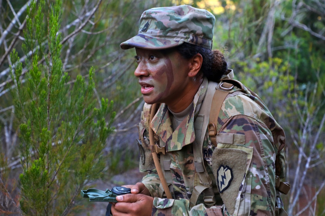 A soldier uses a lensatic compass during land navigation qualification.