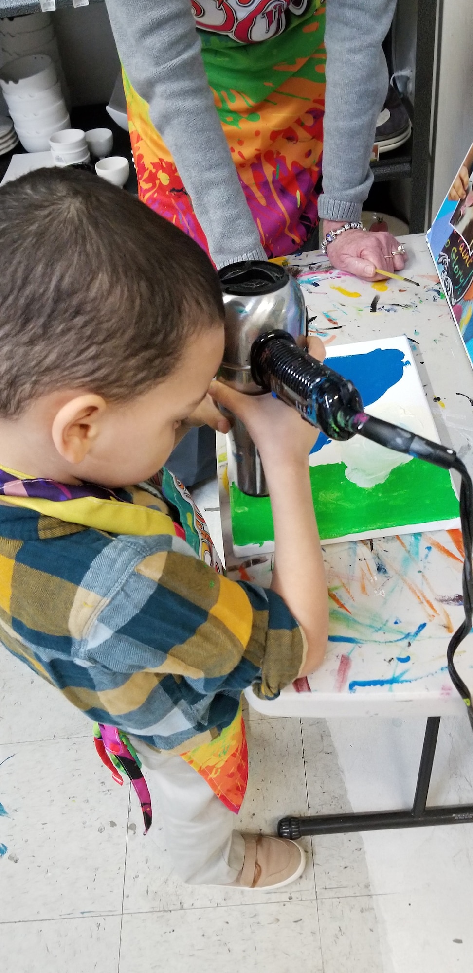 An Exceptional Family Member Program participant dries his artwork after a Creative Art Afternoon Jan. 19, 2018, at a local paint gallery. The EFM Program offers EFMP families the opportunity to partake in various activities/camps throughout the year. (Courtesy photo)
