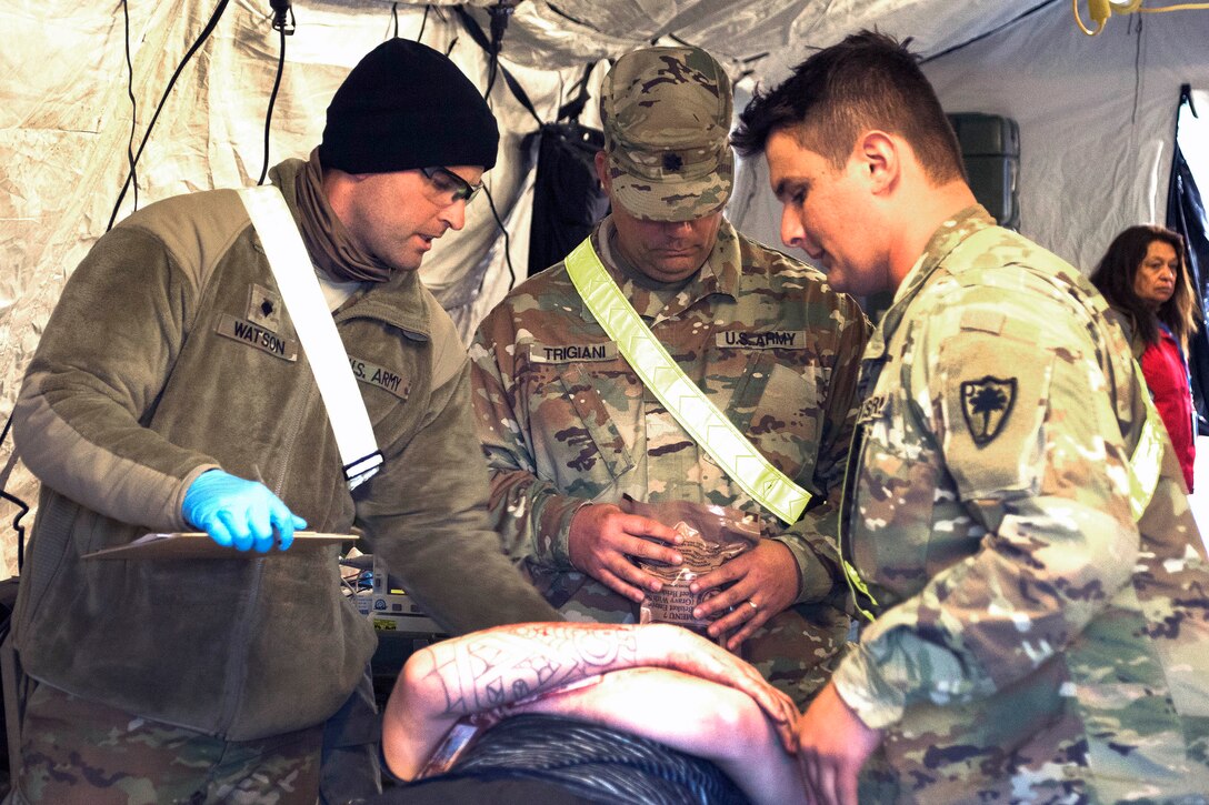 Soldiers process a simulated casualty during a training exercise.