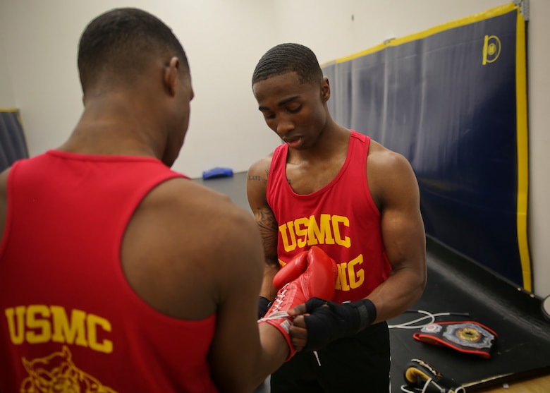 Cpl. Oubigee Jones assists Lance Cpl. Keandre Blackshire before sparring aboard Marine Corps Air Station Beaufort April 17.