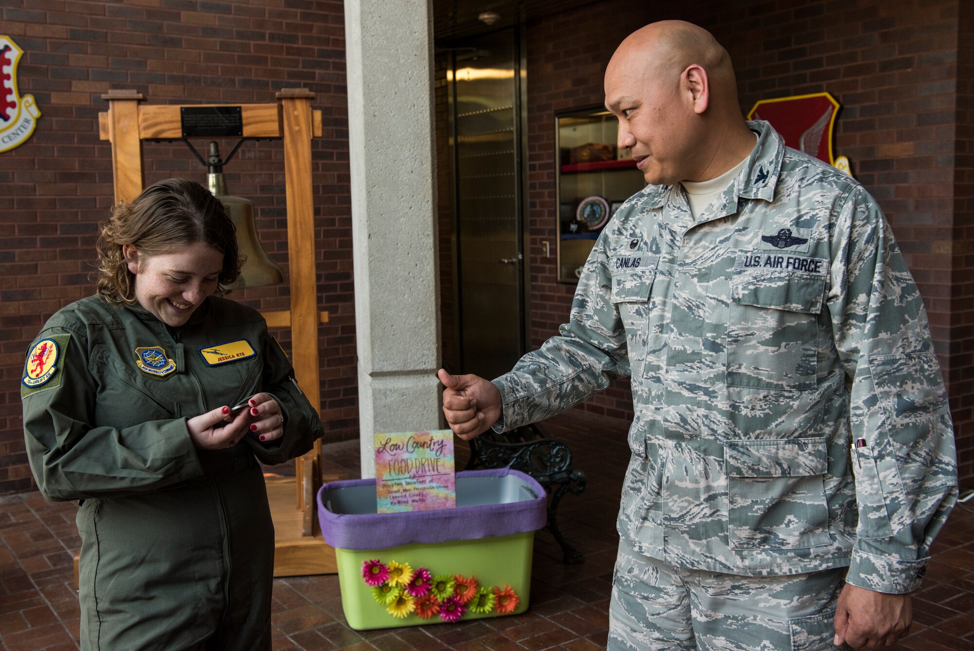 Jessica Rye, left, 17-year-old cancer survivor, admires a coin Col. Jimmy Canlas, right, 437th Airlift Wing commander, presented to her April 12, 2018, at Joint Base Charleston, S.C.