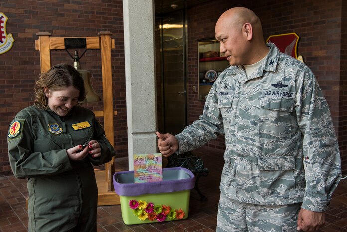 Jessica Rye, left, 17-year-old cancer survivor, admires a coin Col. Jimmy Canlas, right, 437th Airlift Wing commander, presented to her April 12, 2018, at Joint Base Charleston, S.C.