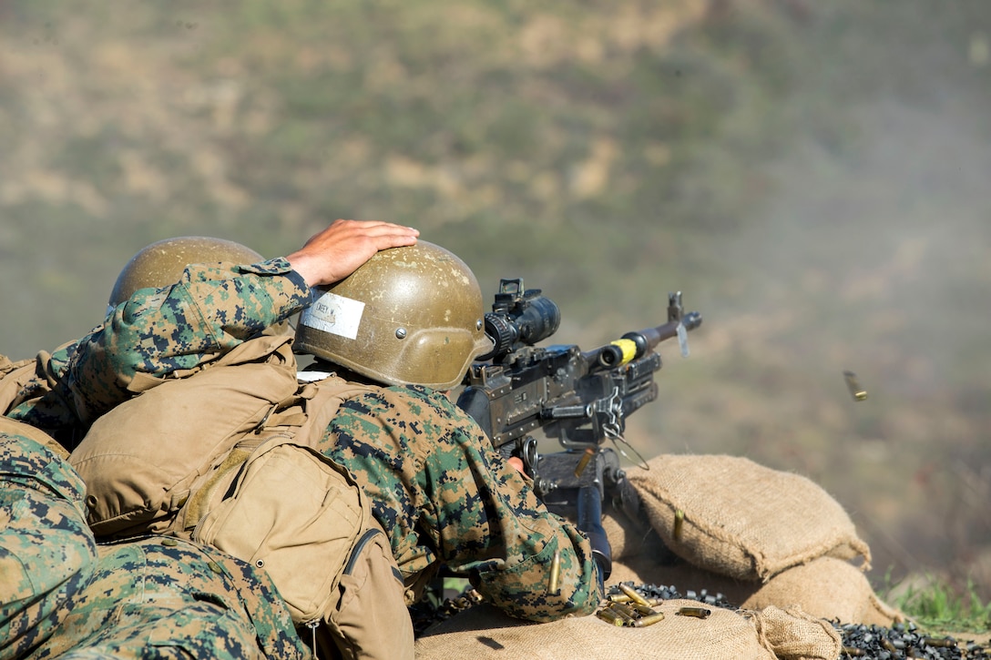 A Marine shoots a machine gun.