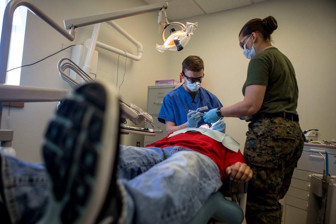 U.S. Navy Lt Commander John Morris (left), a dental officer with 4th Dental Battalion, 4th Marine Logistics Group, and U.S. Navy HM2 Crissey Bearden (right), a dental assistant with 4th Dental Bn., provide dental service to locals as part of Innovative Readiness Training Arctic Care 2018, Buckland, Alaska, April 18, 2018.