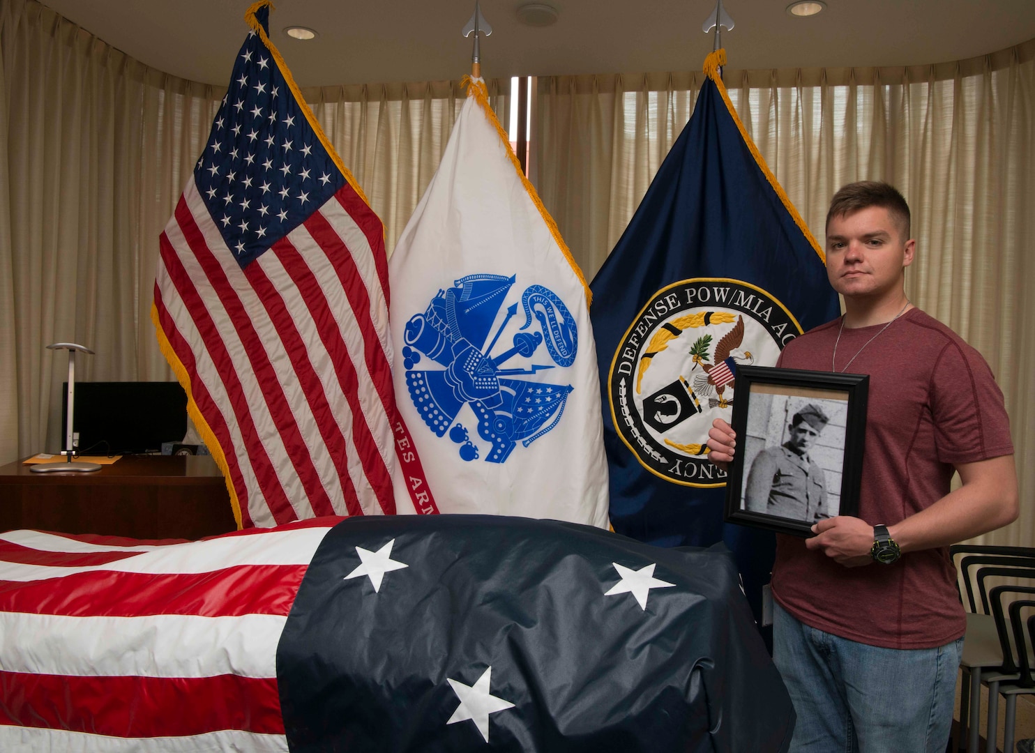 U.S. Army Spc. Zachary Boney poses next to the remains of his deceased great grandfather, U.S. Army Master Sgt. Finley Davis during a tour of the Defense POW/MIA Accounting Agency (DPAA) on Joint Base Pearl Harbor - Hickam, Hawaii, April 16, 2018. Master Sgt. Finley served in Delta comany, 2nd engineer battalion, 2nd Infantry Division when he was captured as a prisoner of war in Kunu-ri, camp 5, North Korea. (U.S. Army Photo by Staff Sgt. Jamarius Fortson)