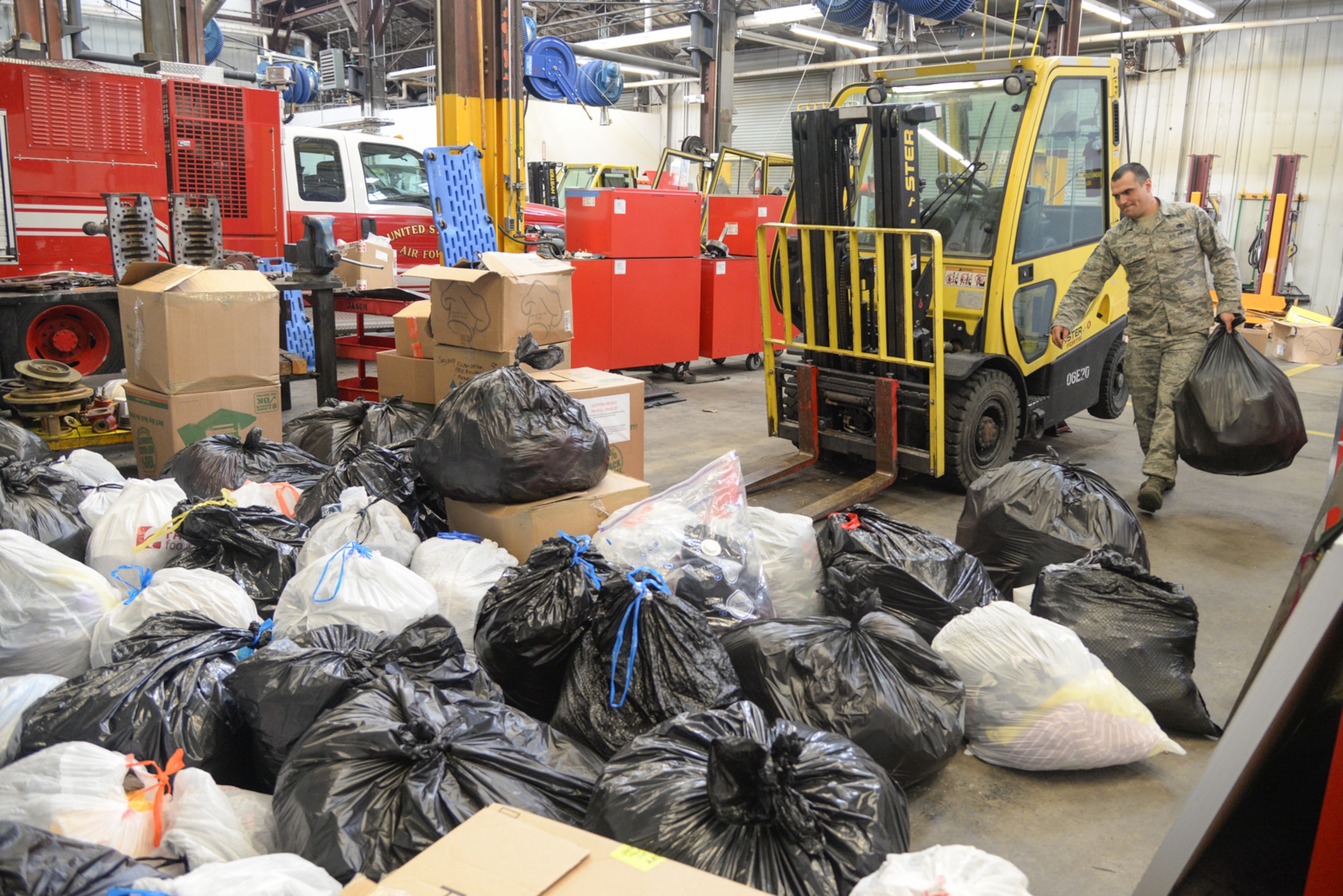 TSgt Tanner Atwood, 75th Logistics Readiness Squadron Vehicle Maintenance, gathers the bags of clothing collected during a Hill Air Force Base clothing drive April 12, 2018, to take to The Lantern House and St. Anne's Center, homeless shelters in Ogden, Utah. (U.S. Air Force photo by Cynthia Griggs)