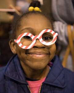 Jodi, 7, daughter of Spc. Ebony Trimmings, poses with a prop at the staged photo booth area during the Month of the Military Child Carnival at Joint Base Elmendorf-Richardson’s 2Rivers Youth Center, April 13, 2018. The event consisted of games, cotton candy, popcorn, face painting and more. April is the Month of the Military Child, highlighting the significant role military children play in the armed forces community.
