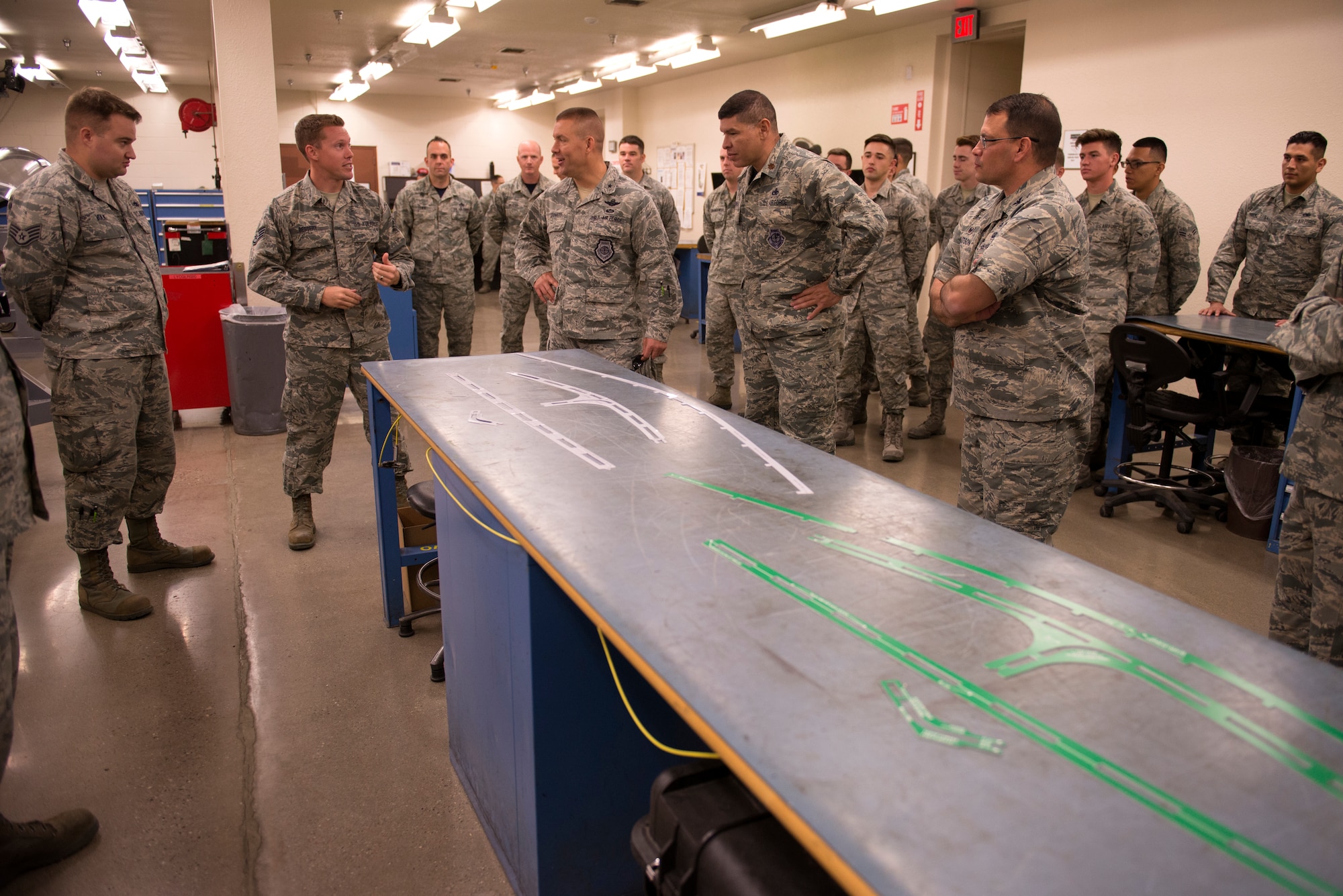 Staff Sgt. Ryan Bessery, 56th Component Maintenance Squadron Egress technician, second from left, briefs Brig. Gen. Brook Leonard, 56th Fighter Wing commander, fifth from left, on new measurement templates for F-35 Lightning II canopy maintenance produced in house April 13, 2018, at Luke Air Force Base, Ariz. Along with other innovations, the egress section has used in-house production of the templates to significantly reduce the replacement time on flexible linear shaped charges in F-35 canopies. (U.S. Air Force photo by Senior Airman Ridge Shan)