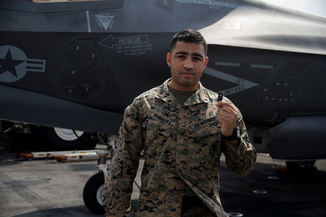 Chief Warrant Officer 2 Daniel Rodriguez, a maintenance officer with Combat Logistics Battalion 31, 31st Marine Expeditionary Unit, holds a 3-D printed plastic bumper for an F-35B Lightning II landing gear door aboard the USS Wasp (LHD-1) while underway in the Pacific Ocean, April 19, 2018. Marines with CLB-31 are now capable of ‘additive manufacturing,’ also known as 3-D printing, which is the technique of replicating digital 3-D models as tangible objects.  The 31st Marine Expeditionary Unit partners with the Navy’s Amphibious Squadron 11 to form the Wasp Amphibious Ready Group, a cohesive blue-green team capable of accomplishing a variety of missions across the Indo-Pacific. (U.S. Marine Corps photo by Cpl. Stormy Mendez/Released)