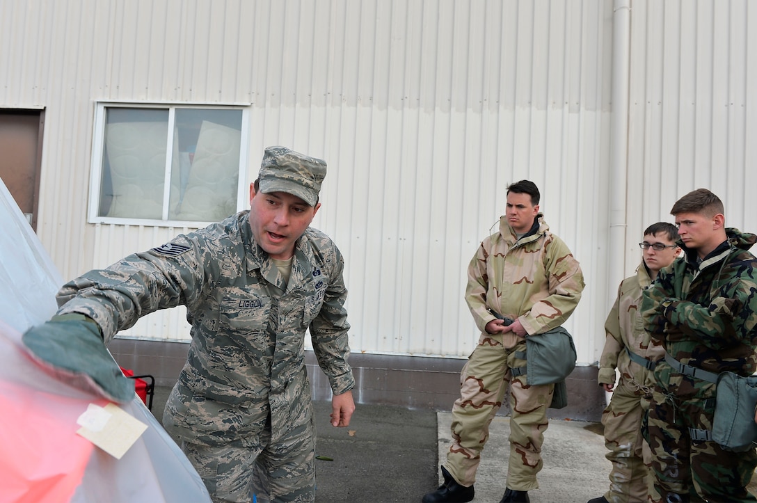 U.S. Air Force Tech. Sgt. Christopher Liggon, 786th Civil Engineer Squadron, non-commissioned officer in charge of chemical, biological, radiological, and nuclear operations, demonstrates decontamination procedures during a training exercise on Ramstein Air Base, Germany, April 12, 2018. The 86th Civil Engineer Group assists with ensuring Ramstein Airmen receive adequate CBRN training. (U.S. Air Force photo by Senior Airman Joshua Magbanua)