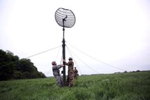 Soldiers raise an antenna