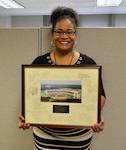 Brenda Hall, a DLA Troop Support procurement analyst, poses with her going-away gift from her time in the DLA Enterprise Rotation Program, Feb. 28, 2018 in Philadelphia.