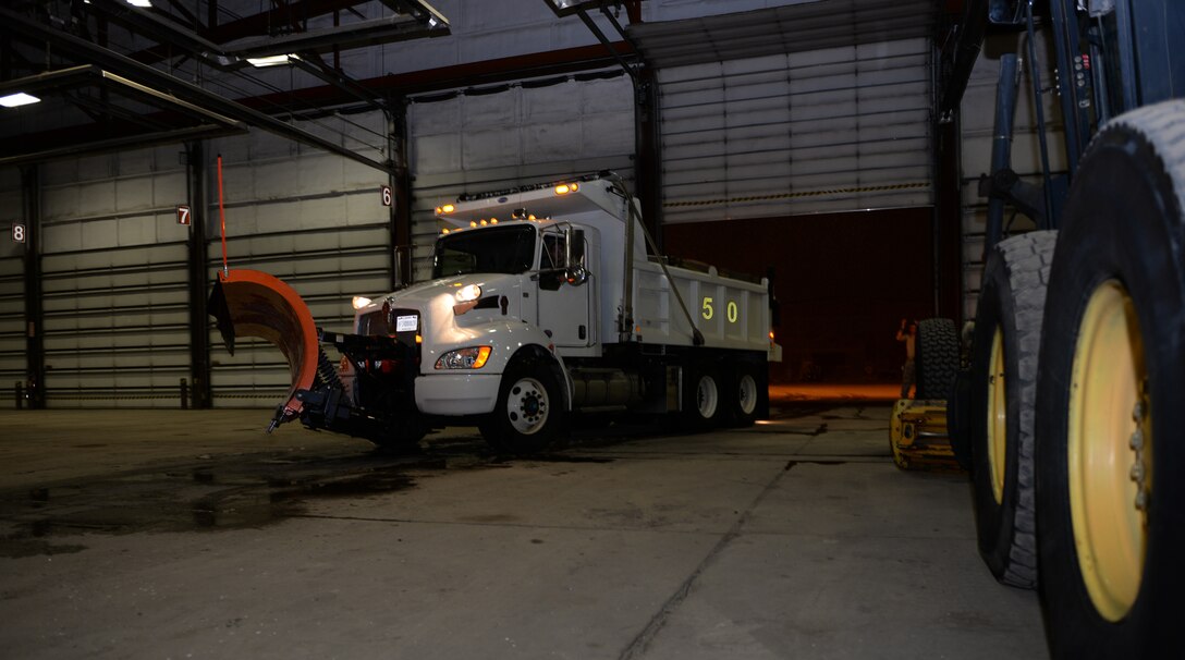 A 28th Civil Engineer Squadron chip truck exits the snow barn during a snow storm at Ellsworth Air Force Base, S.D., April 13, 2018. From October until April, the 28th CES heavy equipment shop prepares for continuous operations to ensure maximum road coverage when weather strikes. (U.S. Air Force photo by Airman 1st Class Nicolas Z. Erwin)