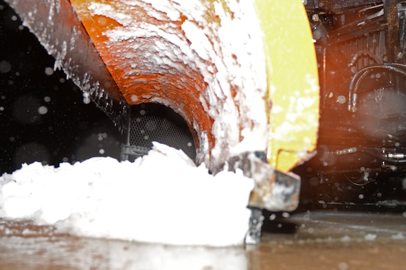 A 28th Civil Engineer Squadron chip truck scrapes snow off a parking lot during a snowstorm at Ellsworth Air Force Base, S.D., April 13, 2018. Non-essential base functions were suspended due to inclement weather, but heavy equipment operators continued on staggered shifts to remove snow from base roads, parking lots and the flight line. (U.S. Air Force photo by Airman 1st Class Nicolas Z. Erwin)