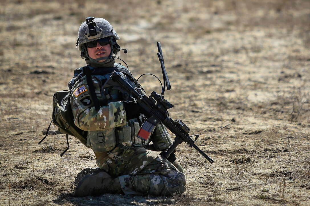 A soldier communicates with his team members.