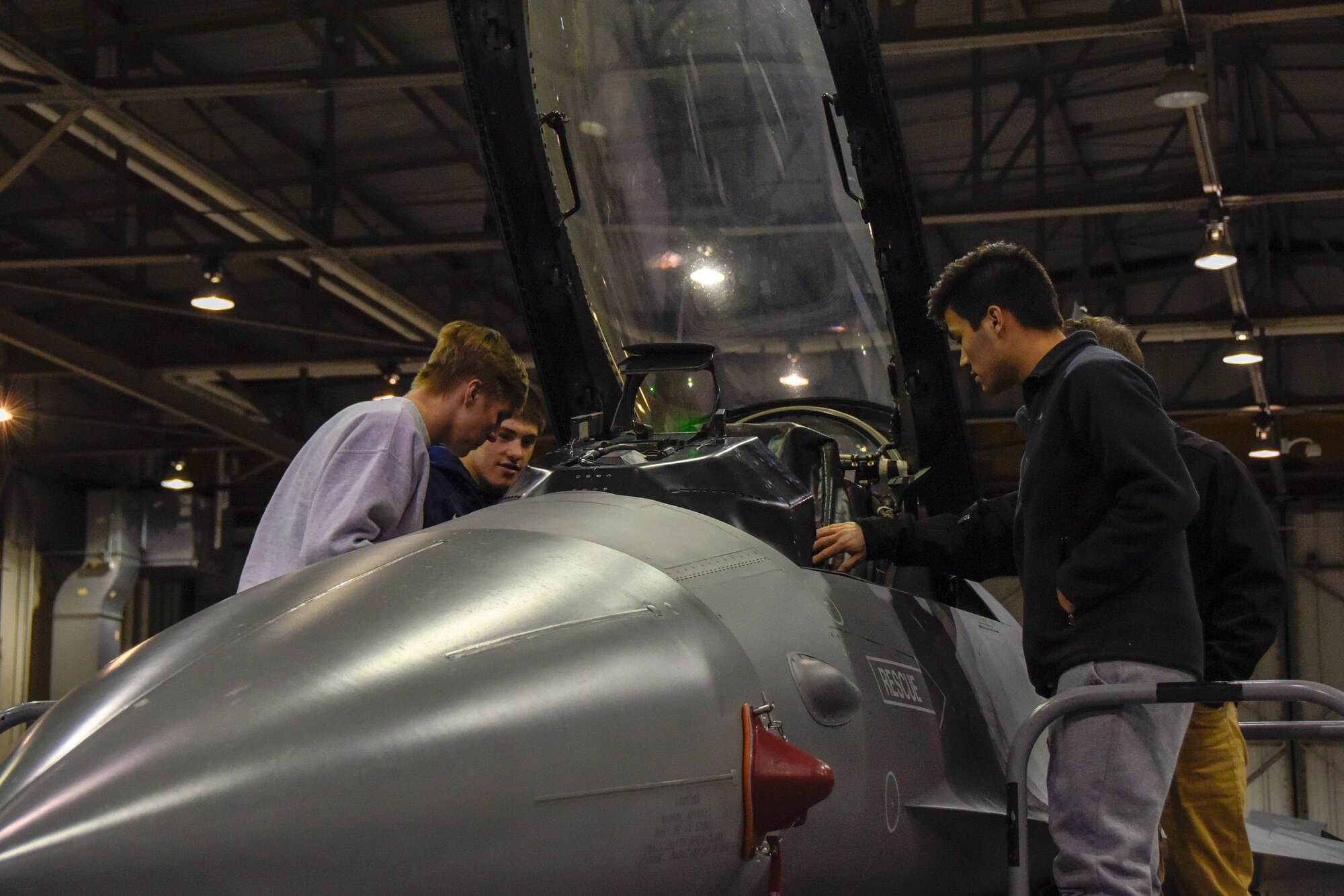 High School students take a quick look at a F-16 Fighting Falcon cockpit during Night Flying Career Day at Joe Foss Field, S.D. on April 17, 2018.