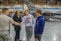 Airmen first class Slade Mutchelknaus, 114th Maintenance Squadron munitions handler, talks with Jaetin DeCou and Tyson Stoebner, juniors from Lennox High School, about his career field during Night Flying Career Day at Joe Foss Field, S.D. on April 17, 2018.