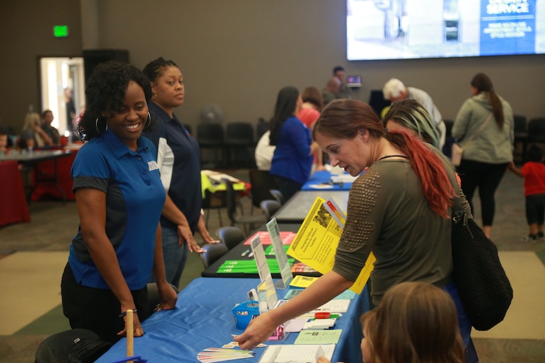 A member of the installation's community visits a booth with her children at the Child Abuse Awareness and Military Child Appreciation Carnival aboard the Marine Corps Air Ground Combat Center, Twentynine Palms, Calif.,  April 12, 2018. The event was held to provide available resources to community members and hold a small fair for children. (U.S. Marine Corps photo by Lance Cpl. Preston L. Morris)