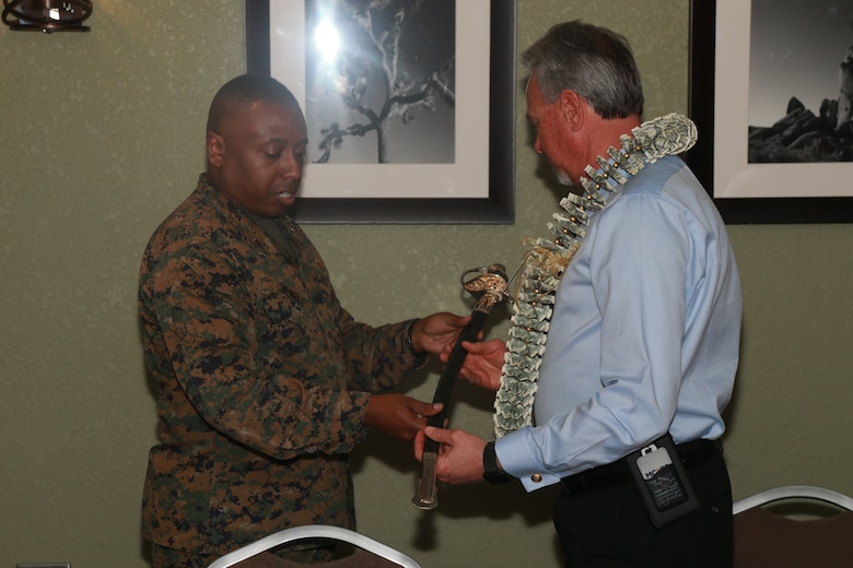Brig. Gen. Dimitri Henry, U.S. Marine Corps Director of Intelligence, presents Larry Stratton, former Deputy Director of Marine Corps Community Services, a non-commissioned officer's sword as a gift during Stratton's retirement ceremony at the Frontline Restaurant aboard the Marine Corps Air Ground Combat Center, Twentynine Palms, Calif., March 29, 2018. Stratton, a retired Marine Corps master sergeant, was Henry's drill instructor at Marine Corps Recruit Depot San Diego, Calif., in 1981. (U.S. Marine Corps photo by Lance Cpl. Preston L. Morris)