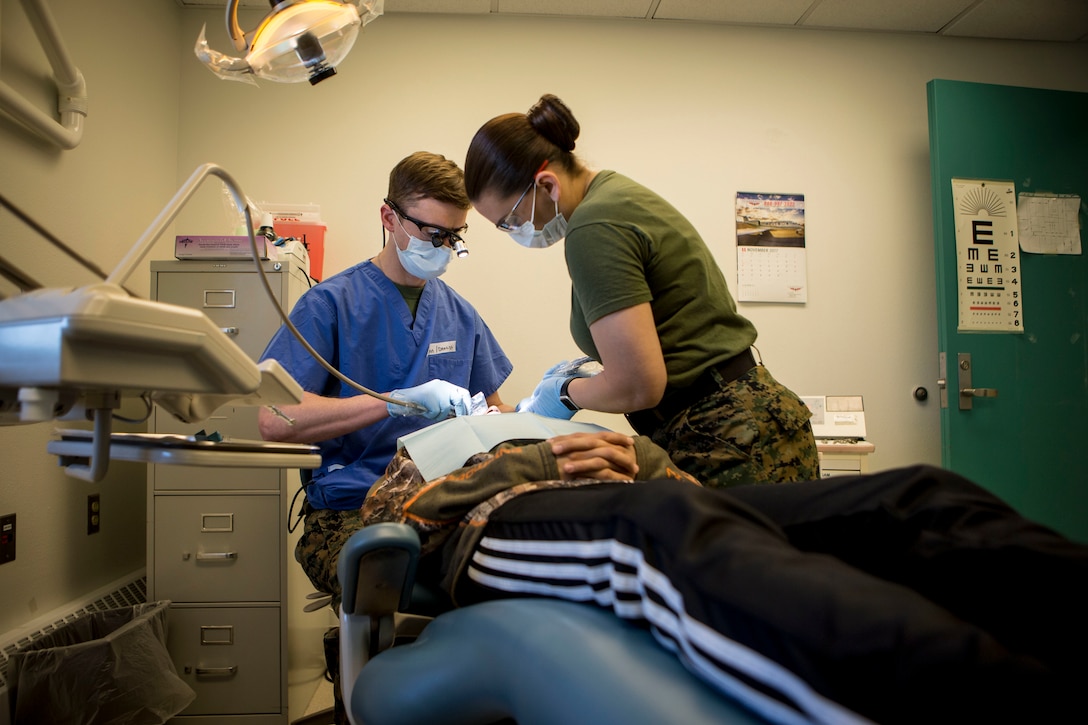 U.S. Navy Lt Commander John Morris (left), a dental officer with 4th Dental Battalion, and U.S. Navy HM2 Crissey Bearden (right), a dental assistant with 4th Dental Battalion provide dental service to locals as part of Innovative Readiness Training Arctic Care 2018, Buckland, Alaska, April 19, 2018.
