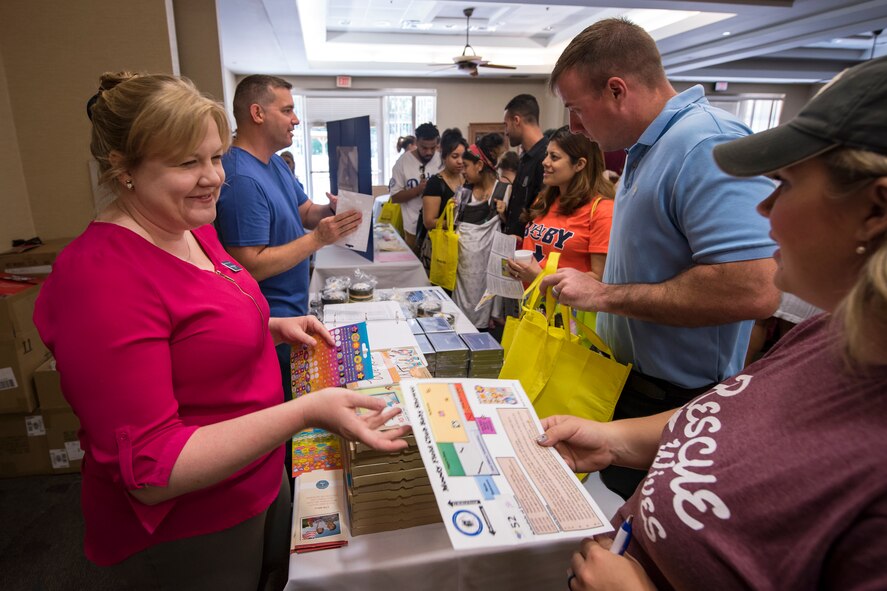 Representatives from the child and youth Behavioral Military and Family Life Counselor program, left, speak to Team Moody families during a baby shower, April 14, 2018, at Moody Air Force Base, Ga. The baby shower provided attendants with various gifts and educational opportunities, the shower’s main focus this year was on raising awareness to the issue of child abuse. (U.S. Air Force photo by Airman 1st Class Eugene Oliver)