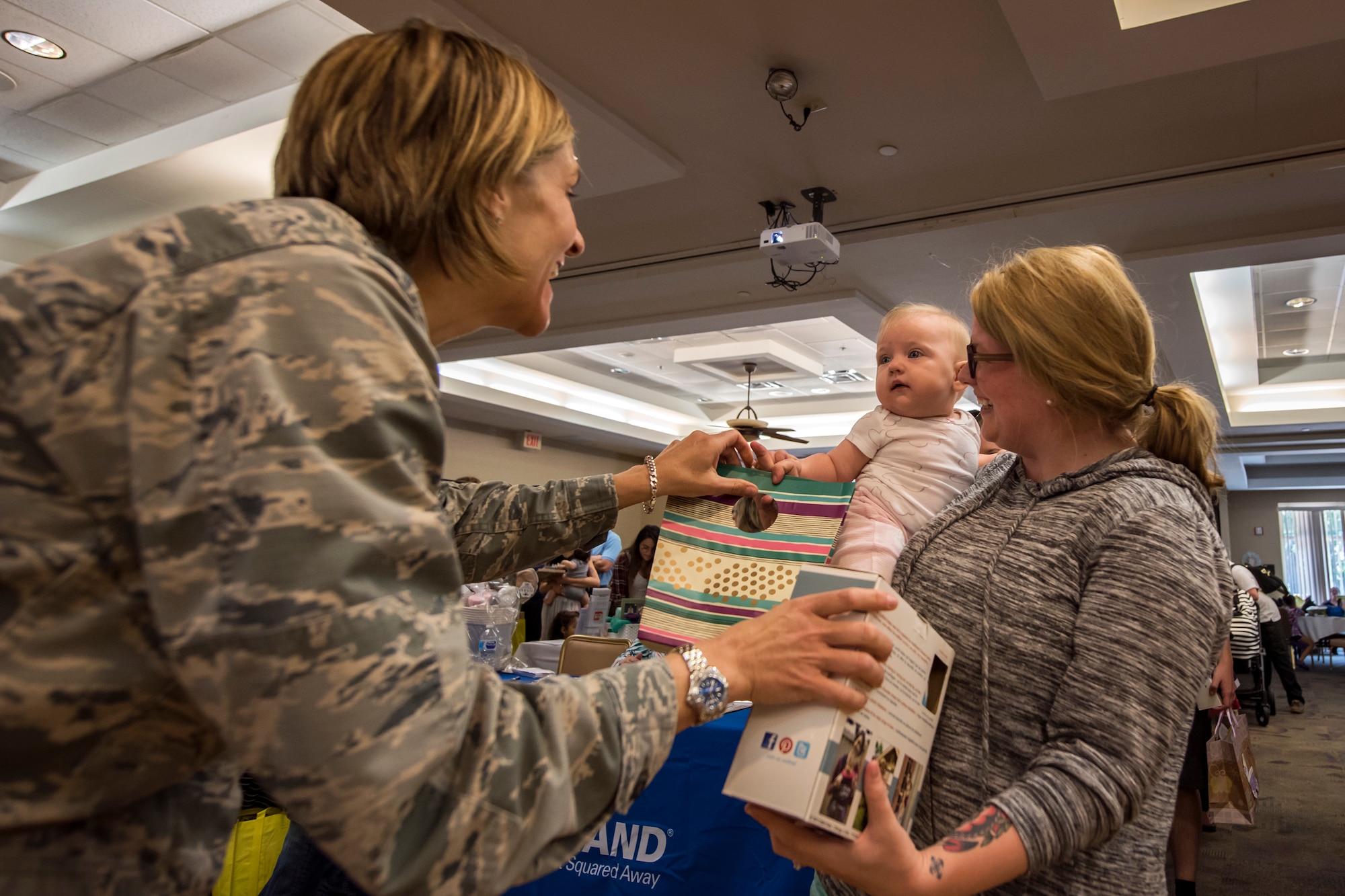 Col. Jennifer Short, left, 23d Wing Commander passes a prize to a Team Moody spouse and child during a baby shower, April 14, 2018, at Moody Air Force Base, Ga. The baby shower provided attendants with various gifts and educational opportunities, the shower’s main focus this year was on raising awareness to the issue of child abuse. (U.S. Air Force photo by Airman 1st Class Eugene Oliver)