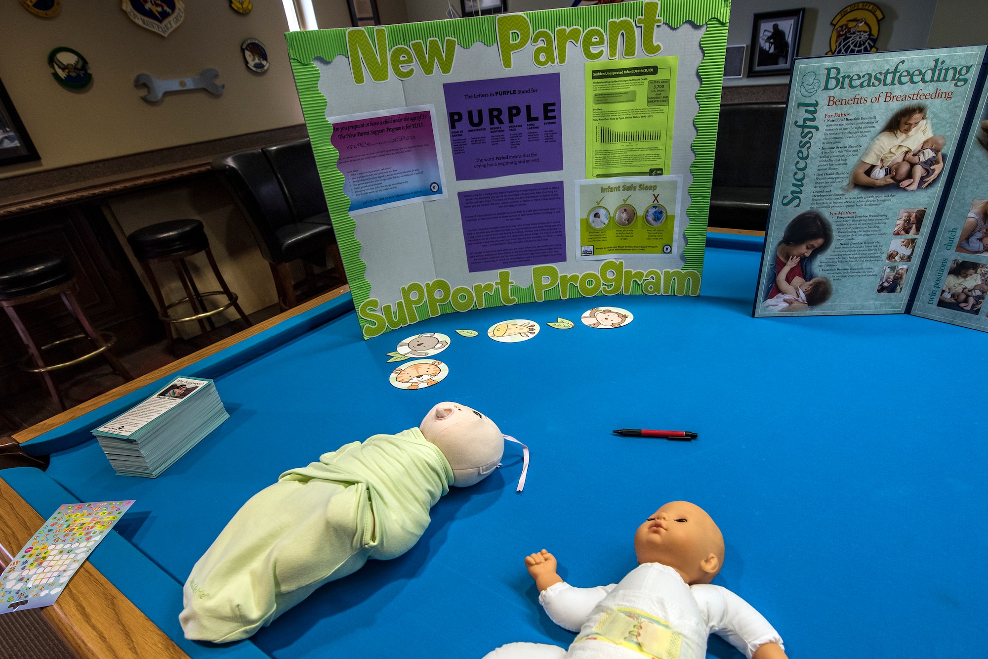 Baby dolls and poster boards containing information regarding child care rest on a table during a baby shower, April 14, 2018, at Moody Air Force Base, Ga. The baby shower provided attendants with various gifts and educational opportunities, the shower’s main focus this year was on raising awareness to the issue of child abuse. (U.S. Air Force photo by Airman 1st Class Eugene Oliver)