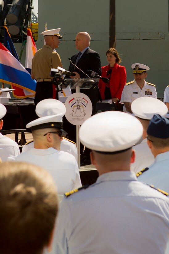 Mitch Landrieu (right), mayor of New Orleans, presents a gift of gratitude to Lt. Gen. Rex C. McMillian (left), commander of Marine Forces Reserve and Marine Forces North, during the mayoral welcome for Navy Week at the Port of New Orleans, April 20, 2018.