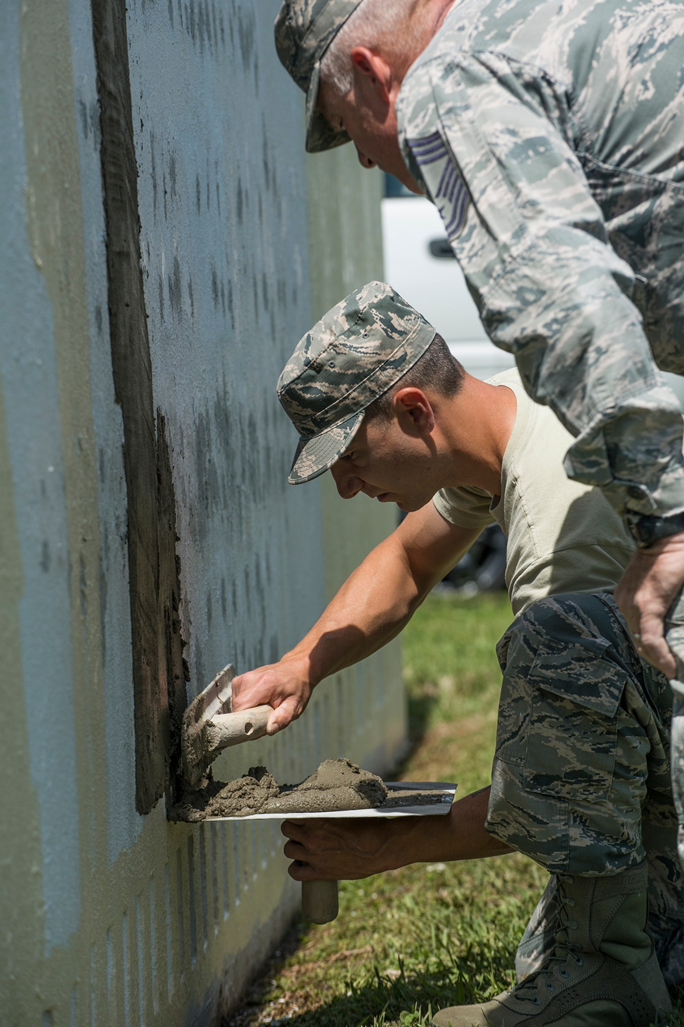 An Airmen assigned to the 307th Civil Engineer Squadron is learning how to evenly and smoothly spread concrete to fill holes in the 307th Bomb Wing headquarters sign on April 11, 2018, Barksdale Air Force Base, La.