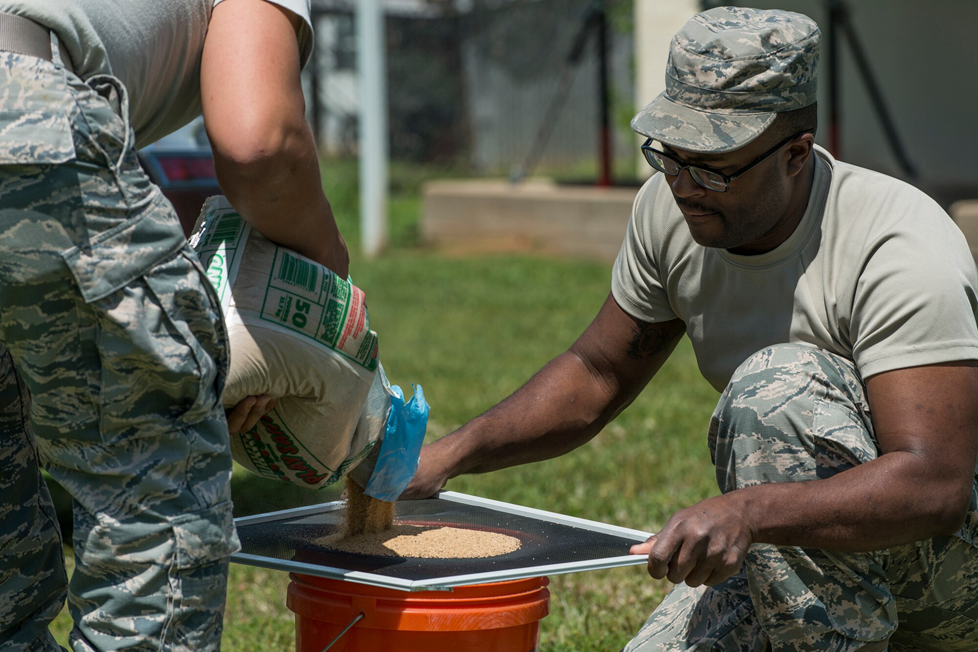 Airmen assigned to the 307th Civil Engineer Squadron ready concrete mix that will be used to fill holes in the 307th Bomb Wing headquarters sign on April 11, 2018, Barksdale AFB, La.