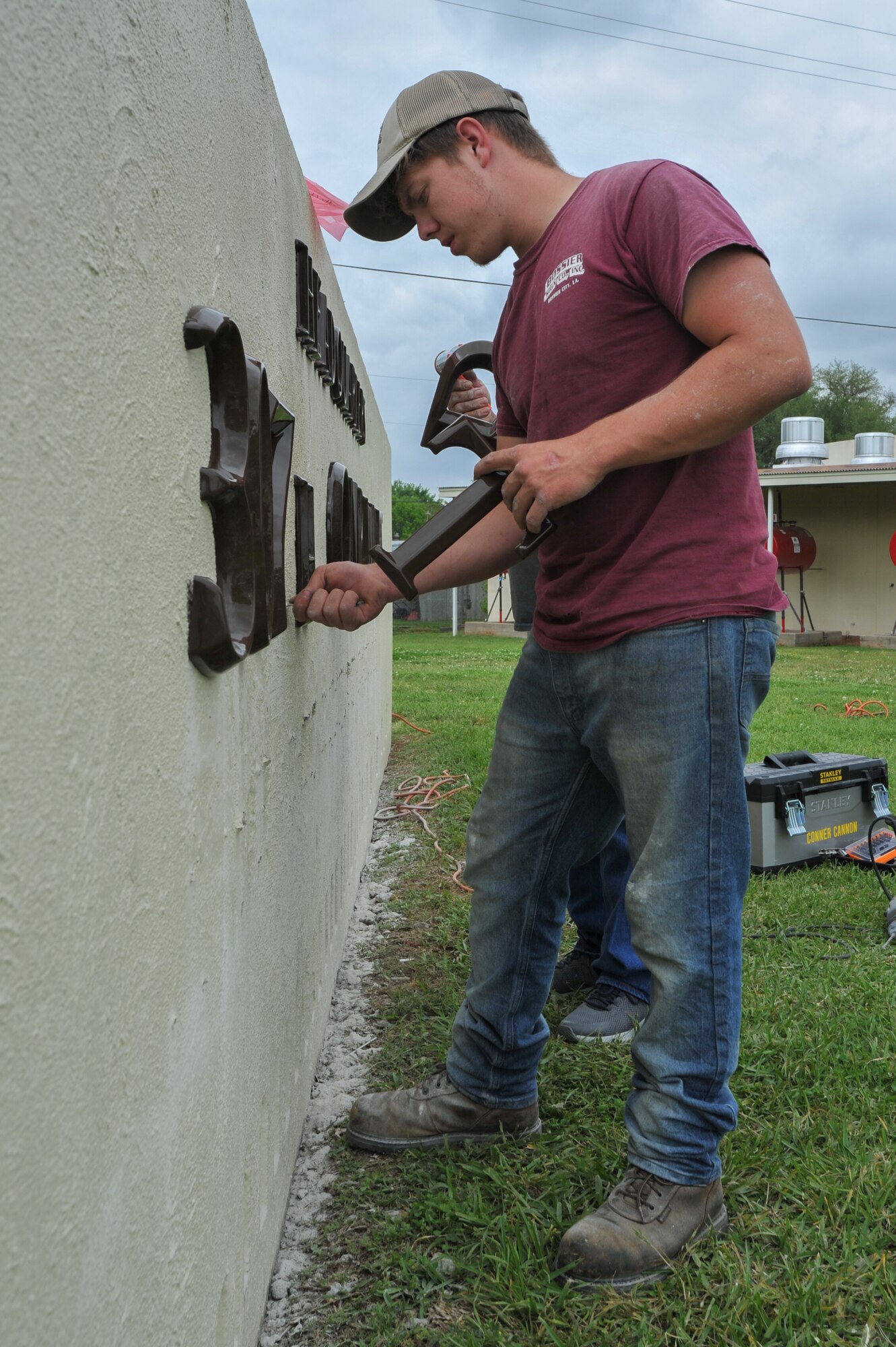 Connor Cannon, a worker for Bossier Sign Co, Inc., installs letters on the 307th Bomb Wing headquarters sign at Barksdale Air Force Base, La., April 18, 2018.