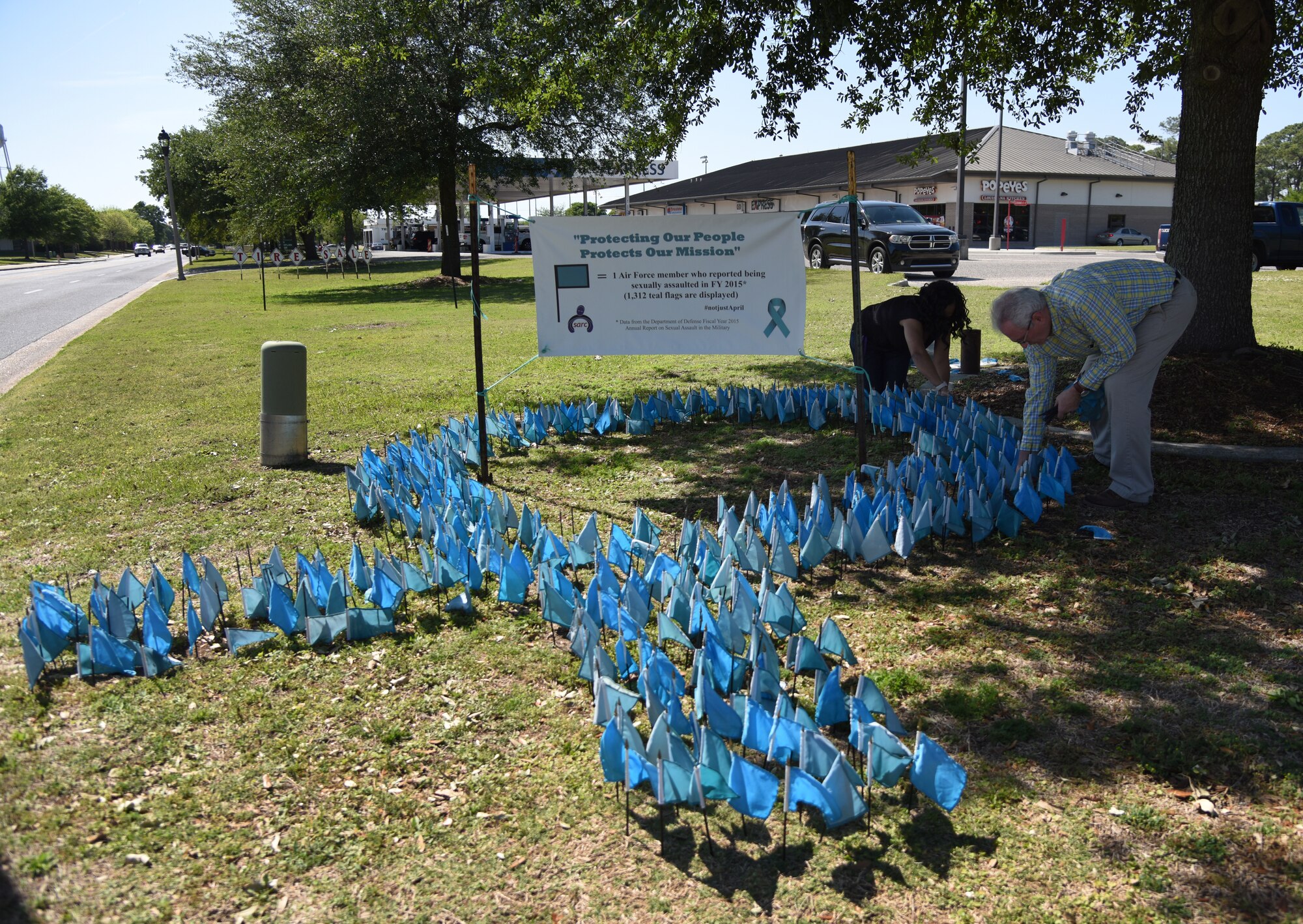 Barry Newman, 81st Training Wing sexual assault response coordinator, and Angie Woods, 81st TRW sexual assault prevention and response program specialist, place flags in the ground for Sexual Assault Awareness Month near the intersection of Larcher Blvd. and Meadows Dr. at Keesler Air Force Base, Mississippi, April 18, 2018. Each flag represents one Air Force member who reported being sexually assaulted in fiscal year 2015. The 1,312 flag display will be moved to several locations around the base throughout the month. (U.S. Air Force photo by Kemberly Groue)