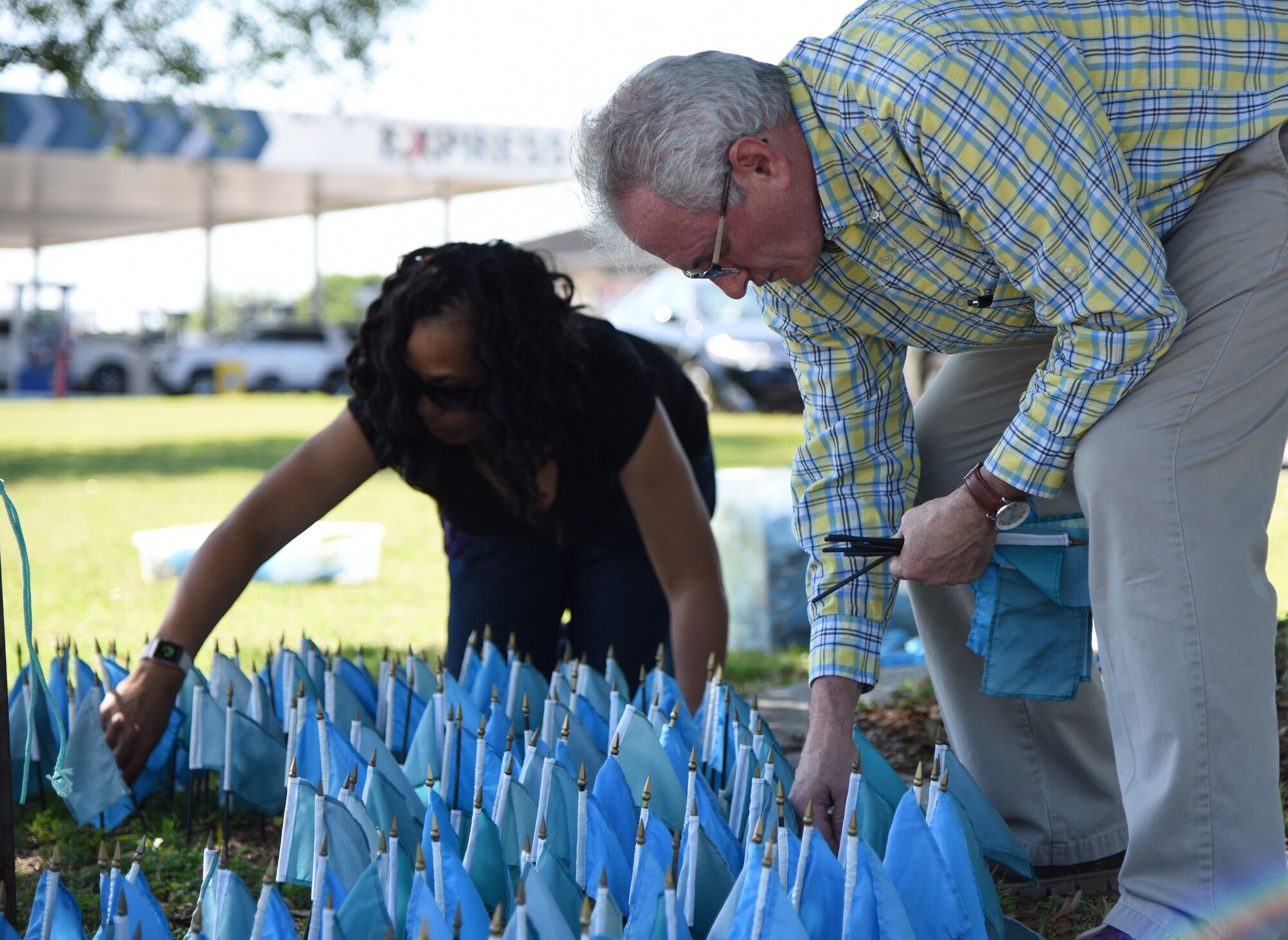 Barry Newman, 81st Training Wing sexual assault response coordinator, and Angie Woods, 81st TRW sexual assault prevention and response program specialist, place flags in the ground for Sexual Assault Awareness Month near the intersection of Larcher Blvd. and Meadows Dr. at Keesler Air Force Base, Mississippi, April 18, 2018. Each flag represents one Air Force member who reported being sexually assaulted in fiscal year 2015. The 1,312 flag display will be moved to several locations around the base throughout the month. (U.S. Air Force photo by Kemberly Groue)