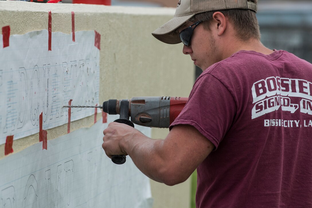 Holes are drilled to secure new letters to the 307th Bomb Wing headquarters sign on April 18, 2018, Barksdale AFB, La.