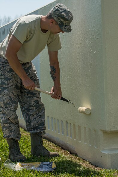 An Airman assigned to the 307th Civil Engineer Squadron applies a fresh coat of paint to the 307th Bomb Wing headquarters sign on April 11, 2018, Barksdale AFB, La.
