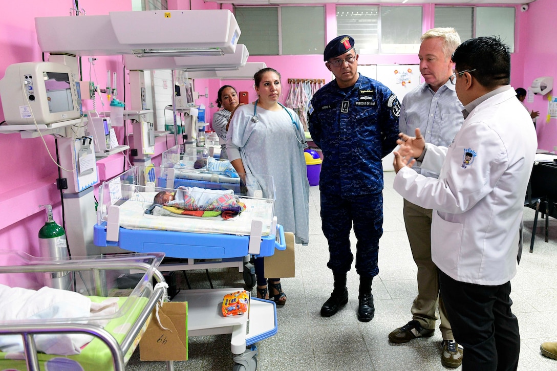 Military officials tour a clinic.