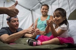 A Navy doctors plays with a child.