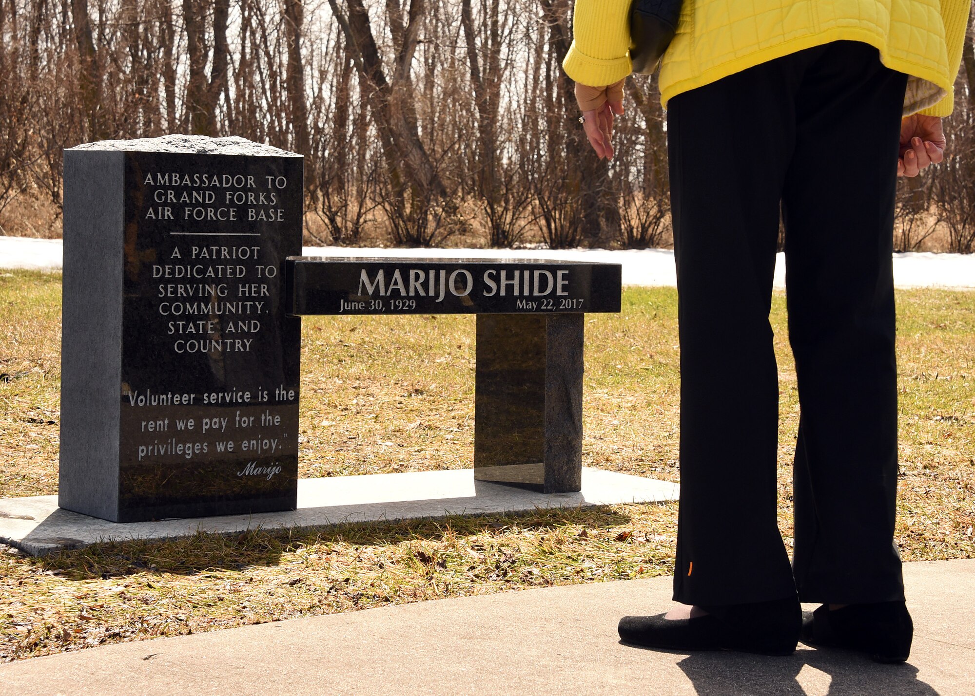 A friend of the late Marijo Shide, Grand Forks Air Force Base Ambassador, admires the new dedicated bench on behalf of Shide, April 20, 2018, on Grand Forks AFB, N.D. More than 50 Airmen, ambassadors, friends and family members gathered in honor of Shide, who lived as an example of her motto, “Volunteer service is the rent we pay for the privileges we enjoy.” (Air Force photo by Airman 1st Class Elora J. Martinez)