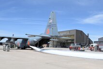 An Air Force Reserve Command 302nd Airlift Wing USDA Forest Service Modular Airborne Fire Fighting System-equipped C-130 Hercules aircraft blasts 3,000 gallons of water at Peterson Air Force Base, Colorado, April 19, 2018.