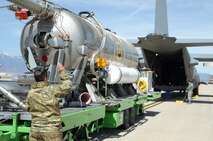Staff Sgt. Anne Lepillez, a 731st Airlift Squadron C-130 Hercules aircraft loadmaster, directs a USDA Forest Service Modular Airborne Fire Fighting System aircraft loading trailer toward a C-130 at Peterson Air Force Base, Colorado, April 19, 2018.