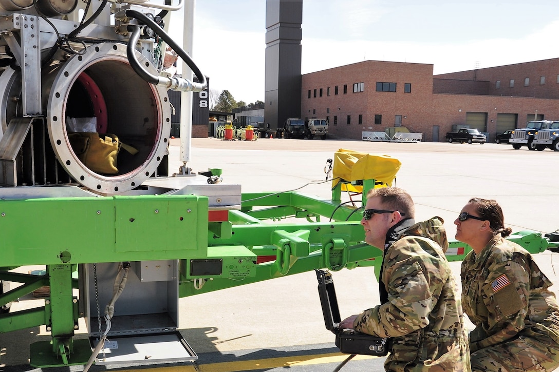 Staff Sgt. Michael Allen, a 731st Airlift Squadron C-130 Hercules aircraft loadmaster, makes adjustments to a USDA Forest Service Modular Airborne Fire Fighting System aircraft loading trailer while Senior Master Sgt. Nattessa Gilbert, a 731st AS loadmaster and MAFFS trainer, offers instruction at Peterson Air Force Base, Colorado, April 19, 2018.