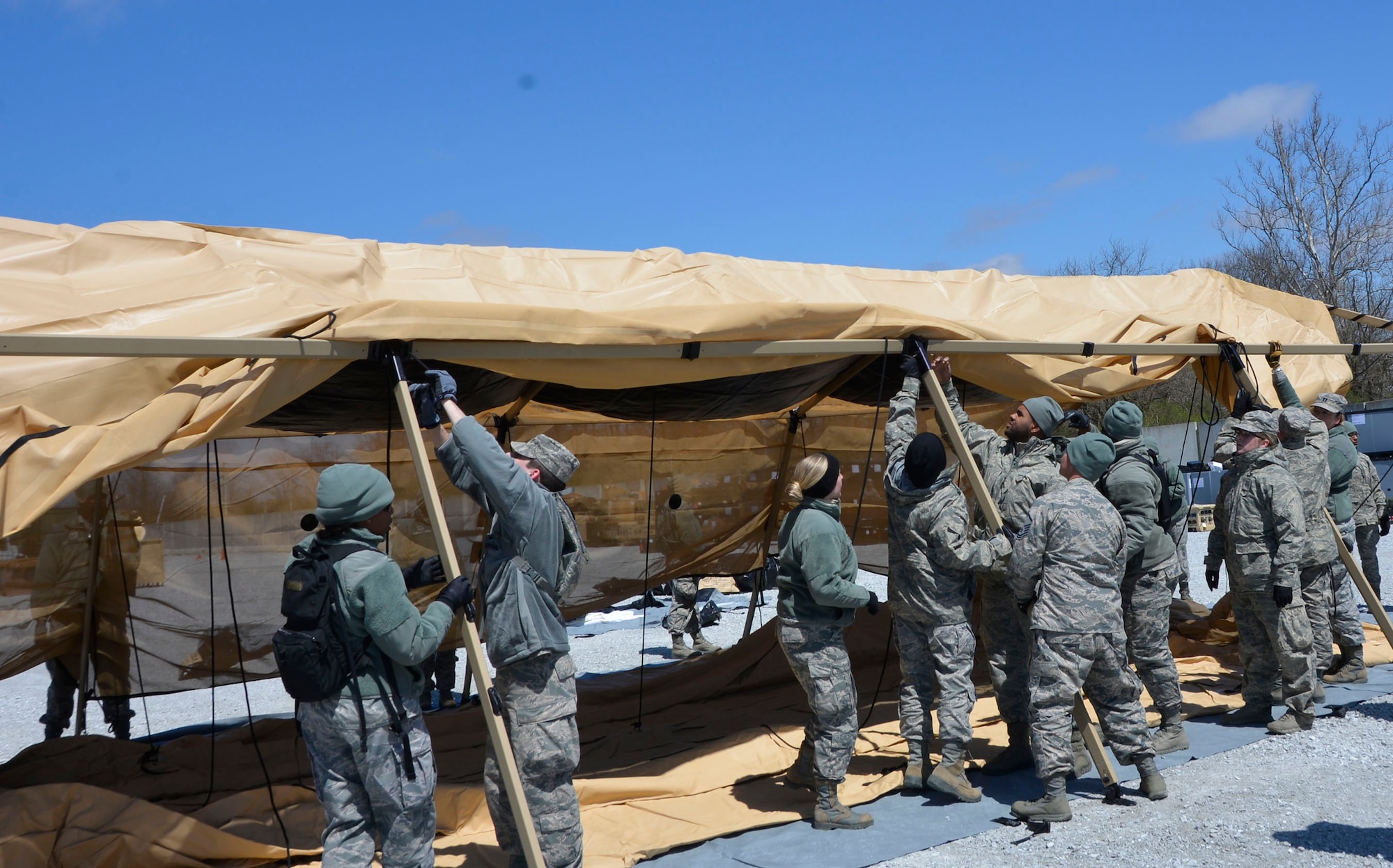 Members of the 81st Medical Group put up a tent side during the Expeditionary Medical Support field confirmation exercise at Camp Atterbury, Indiana, April 17, 2018. The confirmation exercise evaluated the tactics, techniques and procedures of EMEDS operations during a domestic U.S. contingency such as a natural disaster. (U.S. Air Force photo by Mary McHale)